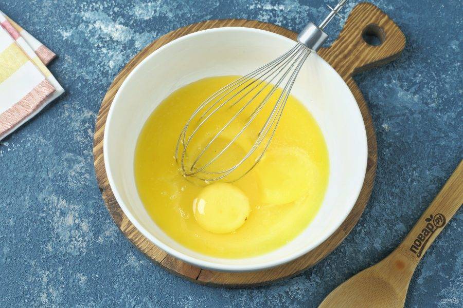 В глубокую миску разбейте яйцо. Второе отдельно взболтайте и отделите половину, добавьте к первому яйцу. Сюда же добавьте сахар.