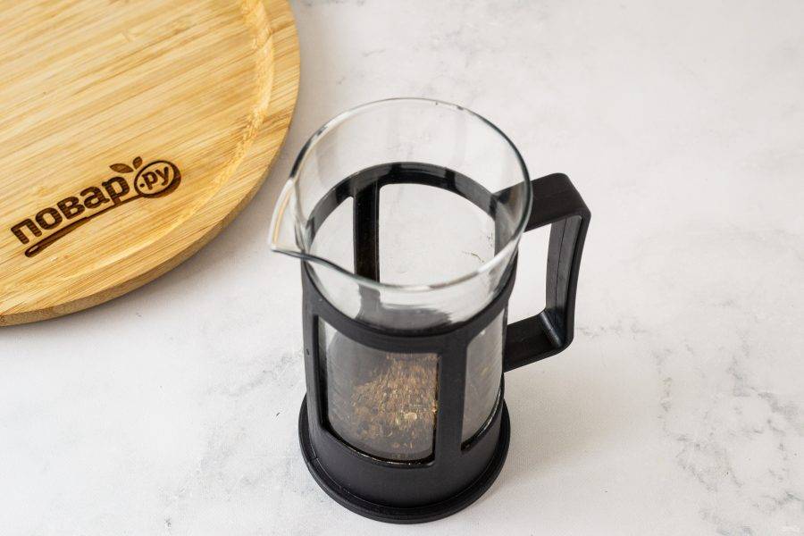 Переложите молотый кофе и измельченные пряности во френч-пресс.