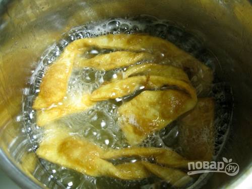 В казанок или глубокую сковороду влейте растительное масло. Его должно быть достаточно много, главное, чтобы заготовки теста в нём плавали. За раз обжаривайте по несколько заготовок до румяности. 