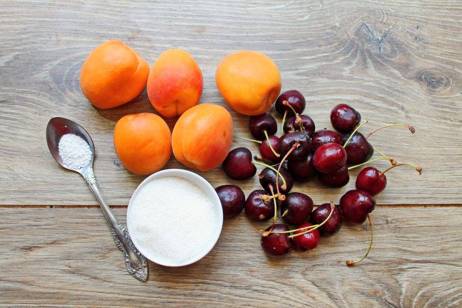 Подготовьте все необходимые ингредиенты для приготовления компота из абрикосов и черешни. Абрикосы и черешню переберите и вымойте.