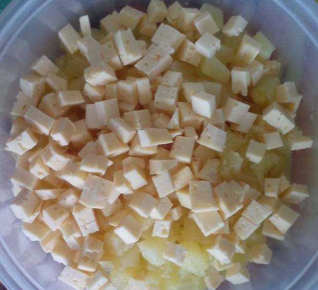 1. Ананасы откинем на дуршлаг, чтобы стекла жидкость, и затем добавим сыр, порезанный кубиками. 