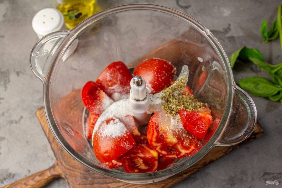 К помидорам добавьте соль, сахар, сушеный орегано. Влейте оливковое масло.