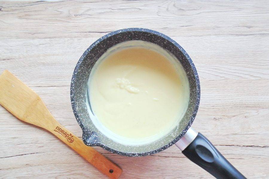 Когда молоко в кастрюле начнет закипать, влейте в него смесь желтков и сахара. Постоянно перемешивайте, пока крем не загустеет.