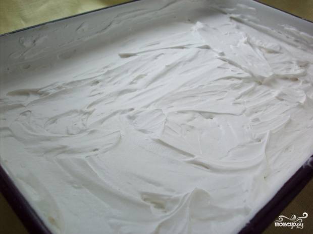 Теперь возьмите заранее подготовленную форму для тирамису и выложите часть крема, равномерно распределяя его по дну, чтобы получился слой в 1,5-2 см.