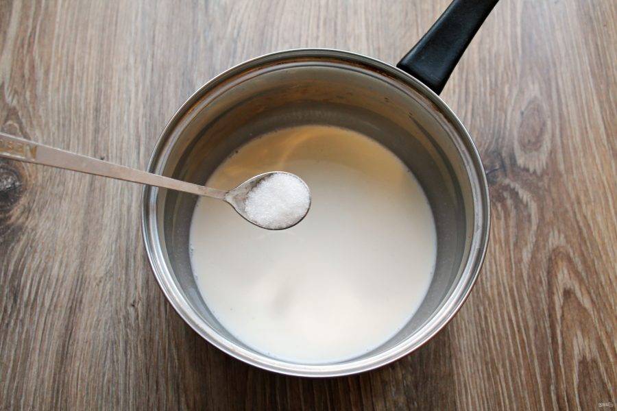 Разделите молоко на две части. Влейте половину в кастрюлю и добавьте сахар, перемешайте. Поставьте на средний огонь и доведите до кипения.