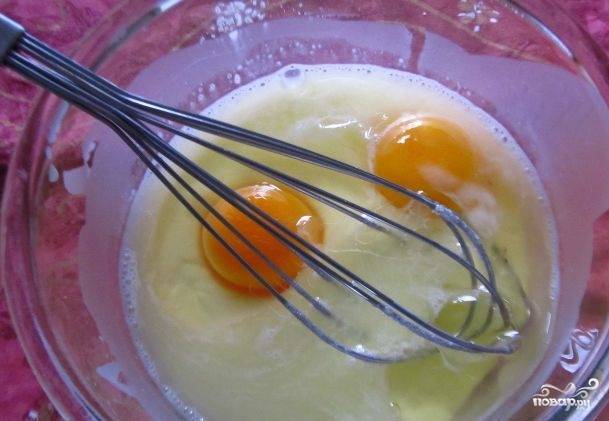 В крахмальную смесь добавьте 2 яйца. Перемешайте её венчиком до единой консистенции.