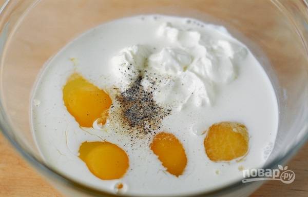 2. В глубокой мисочке соедините молоко, сметану и яйца. Добавьте по вкусу соль и перец. Взбейте все миксером или венчиком до однородности. 