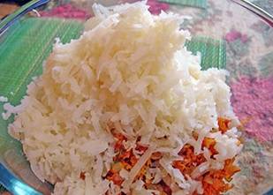 4. Выложите зажарку из сковороды в блюдо сверху риса. Туда же натрите картофель на терке.