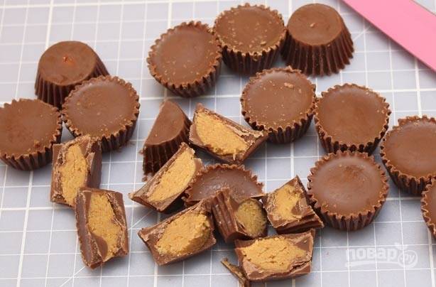 5.	Тем временем часть шоколадных конфет (можно любые) разрежьте пополам, а вторую часть оставьте целыми.
