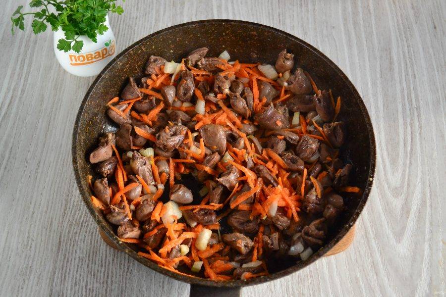 Когда жидкость из сердечек испарится, добавьте в сковороду морковь и лук, обжарьте в течение пары минут.