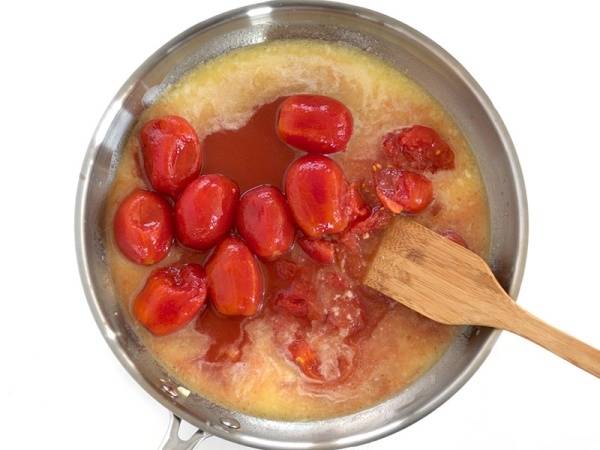 3. Добавьте очищенные от кожицы помидоры, уберите огонь до минимума и оставьте томаты тушиться. 