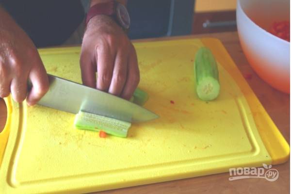 Очистите огурец от кожицы и нарежьте кубиками.