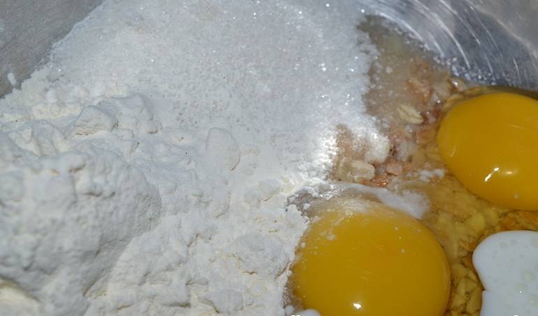 Сливаем воду с овсянки, смешиваем с яйцами, кефиром, мукой, сахаром и разрыхлителем.