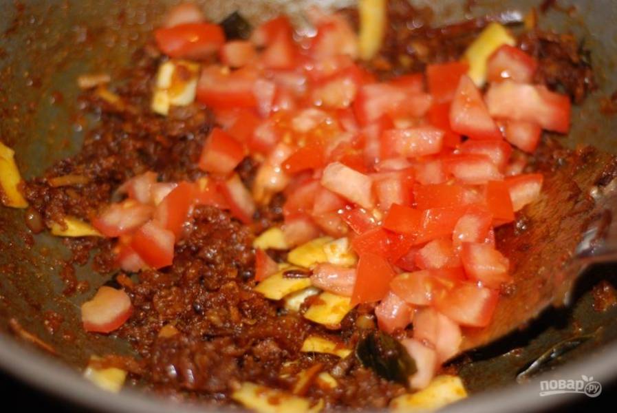 3. Нарежьте небольшими кубиками помидоры и высыпьте в сковороду. Тушите их под крышкой, пока помидоры не станут мягкими.