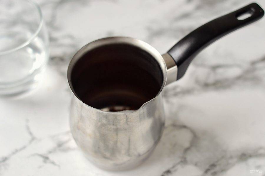 Насыпьте в турку 1,5 ч.л. молотого кофе. Влейте воду и размешайте.