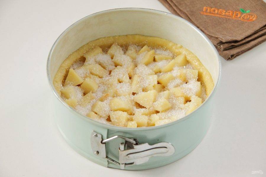 Слейте с айвы воду и выложите ее ровным слоем на тесто в форме. Посыпьте сахаром по вкусу.