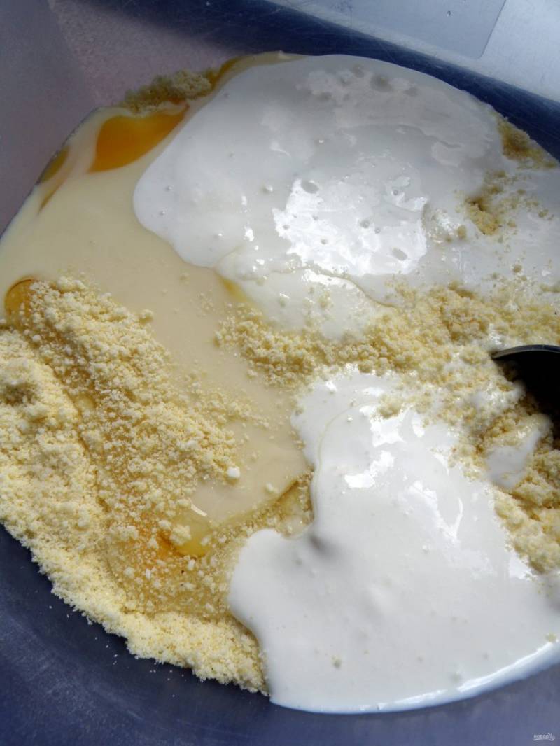 Переложите крошку в просторную миску и добавьте яйцо, сгущенное молоко и густой йогурт без добавок. Всыпьте просеянную с разрыхлителем муку и быстро замесите тесто.