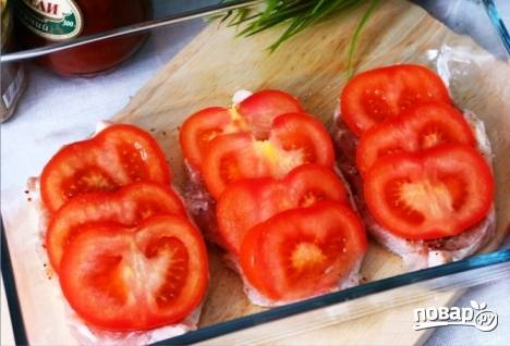 На мясо выкладываем нарезанные помидоры и отправляем форму в разогретую до 180-200 градусов духовку на 30 минут. 