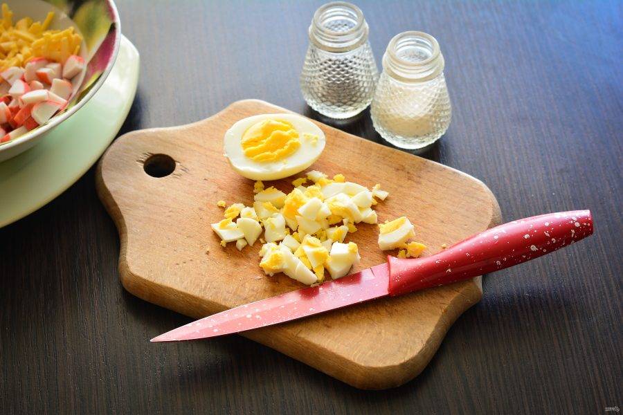 Яйца отварите и остудите. Почистите и нарежьте кубиками среднего размера.