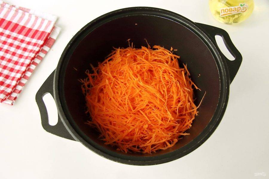 Морковь натрите на терке для корейской моркови или на обычной крупной. Переложите в глубокую миску или кастрюлю.