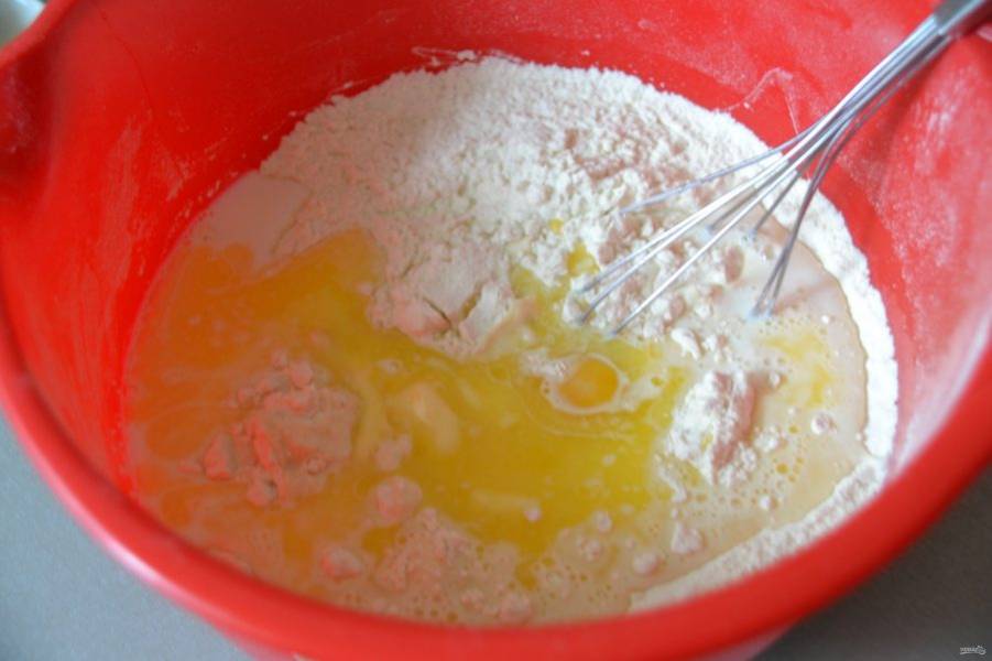 Влейте теплое молоко, вбейте яйцо и добавьте растопленное сливочное масло.