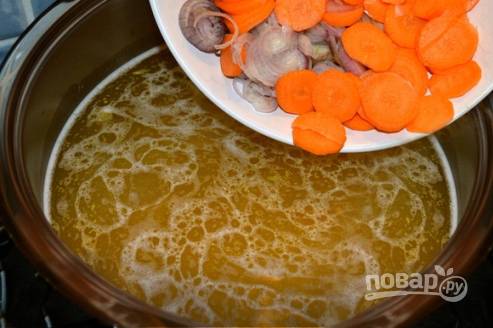 В бульон добавляем нарезанные тонкими кружочками лук-шалот и морковку.