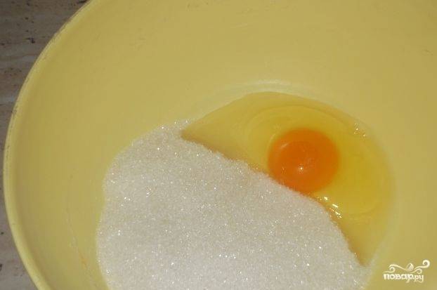 Духовку поставьте разогреваться до 180 градусов. Яйцо взбейте со стаканом сахара.