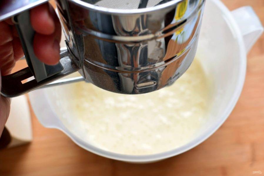Просейте сверху муку, смешанную с разрыхлителем, ванилином и натуральным сухим молоком. Аккуратно и быстро лопаткой перемешайте тесто.