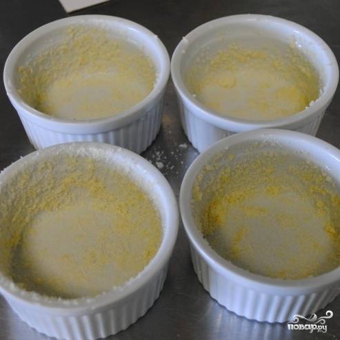 Формочки для суфле смазываем сливочным маслом, присыпаем тертым пармезаном и ставим в морозилку. Из указанного количества ингредиентов получится 4 суфле диаметром 9 см.