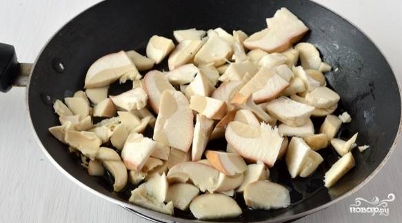 5. Почистите и помойте грибы. Порежьте их на небольшие кусочки. В сковородку влейте растительное масло. Выложите грибы.