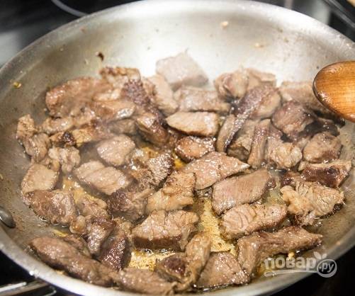 Затем нарежем обжаренное мясо на небольшие кусочки и отправим на сковороду, добавив еще немного масла. Обжариваем, помешивая, до готовности.