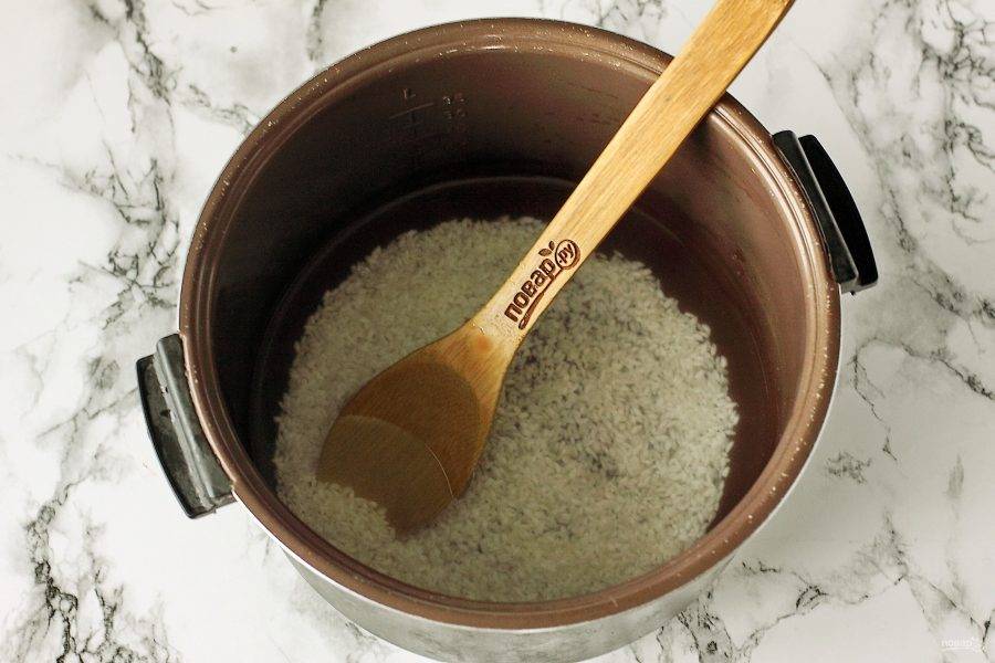 Переложите рис в чашу мультиварки. Добавьте соль, сахар по вкусу и влейте воду. Готовьте на режиме "Молочная каша" 1 час. 
