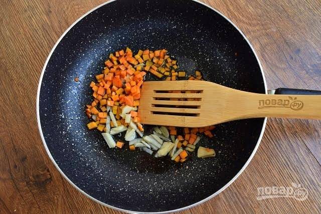 4.    На оставшемся масле обжарьте овощи. Сначала чеснок и морковь – до румяной корочки.

