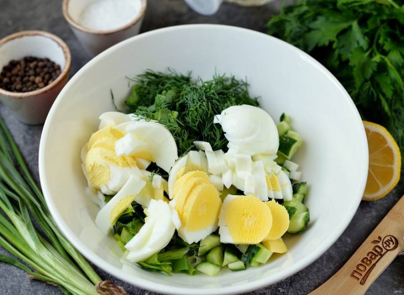 Почистите вареные яйца, порубите зелень и яйца ножом или нарежьте их на яйцерезке, переложите в миску к овощам. 