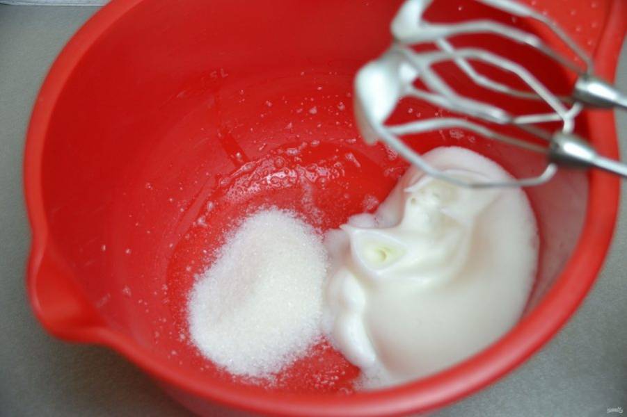Взбейте яичный белок в пышную пену. После этого добавьте частями сахар, продолжая взбивать.