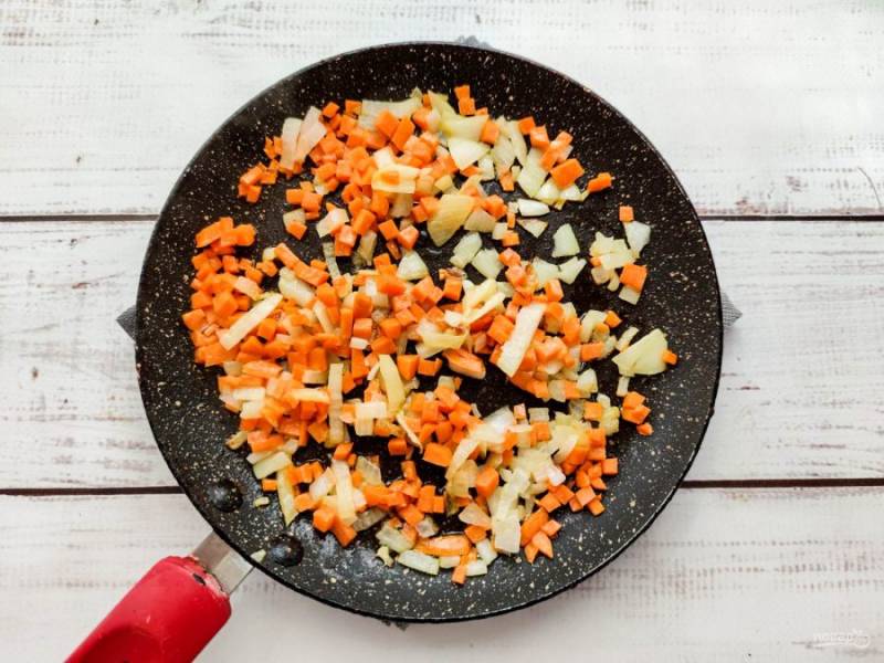 Лук очистите от шелухи и мелко нарежьте. Морковь хорошо помойте и нарежьте небольшими кубиками. Овощи обжарьте в хорошо разогретой сковороде с растительным маслом.