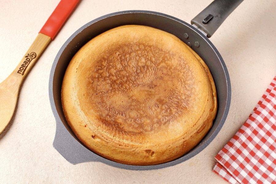 После чего, помогая лопаткой, столкните пирог с тарелки обратно в сковороду. Вновь накройте крышкой и на небольшом огне готовьте ещё 15 минут.