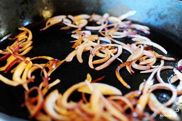 3. Нагреть оливковое масло в сковороде на среднем огне. Добавить нарезанный красный лук и жарить, пока он не станет слегка карамельным. 
