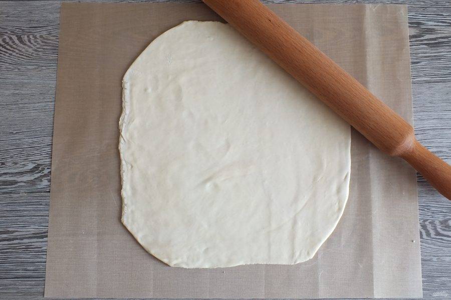 Раскатайте слоёное тесто в пласт толщиной 0,3 см.
