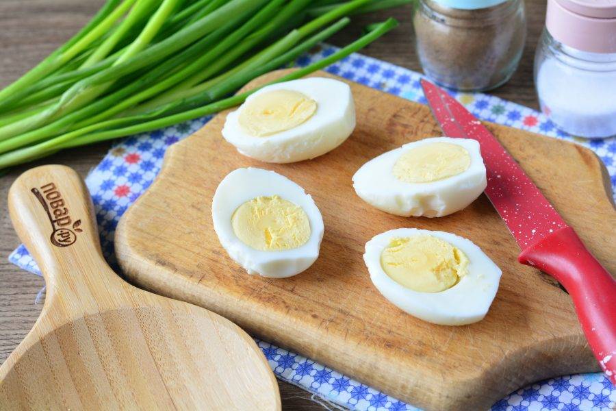 Сварите вкрутую куриные яйца, остудите и почистите. Разрежьте яйца вдоль пополам.