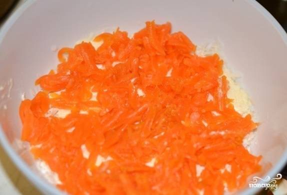 Накрываем наш картофельный слой слоем редьки. Морковку натираем на мелкой терке и выкладываем поверх редьки.