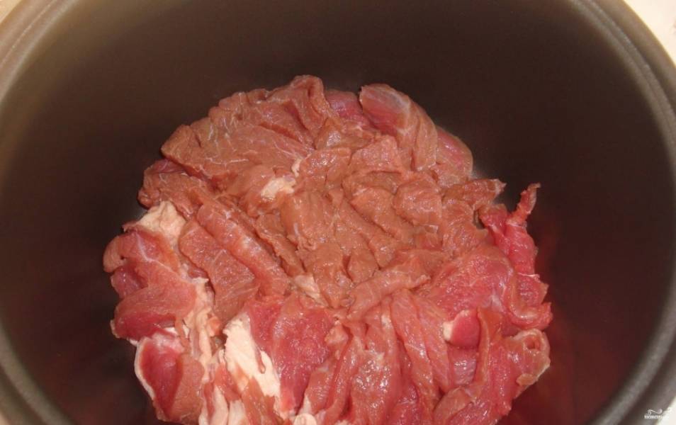 1. Мясо нарежем тоненькими кусочками,немного отобьем. Натираем каждый кусок специями. Выкладываем на дно мультиварки. 