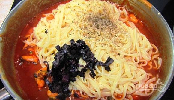 Мидии посолите. Добавьте к ним спагетти, перец и базилик. Перемешайте ингредиенты. Нагревайте их ещё минуту.