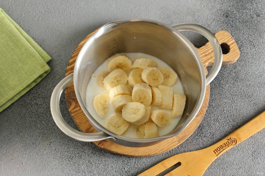 Бананы нарежьте кусочками и сложите в кастрюльку. Добавьте молоко.