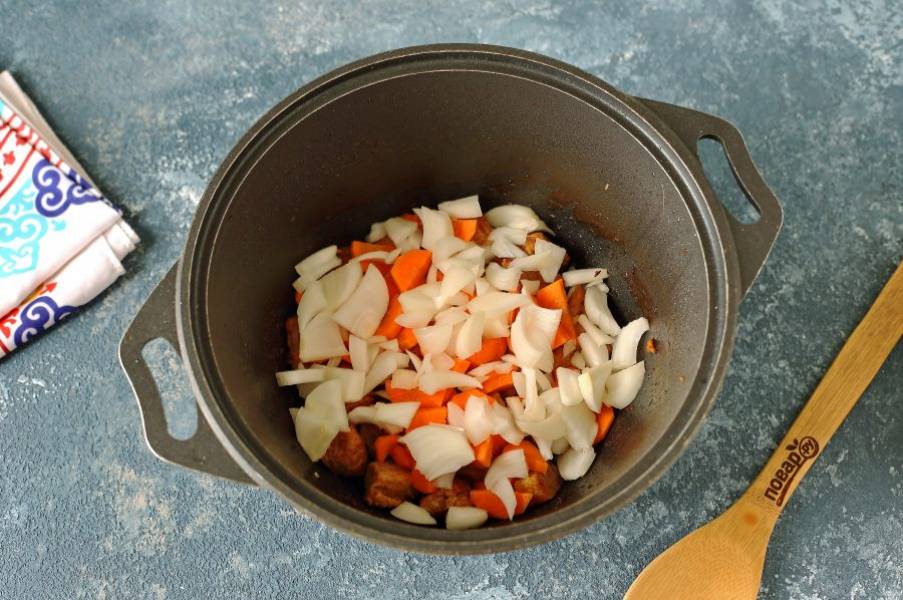 Добавьте нарезанные произвольно лук и морковь.