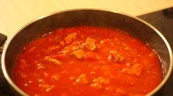 Добавляем к мясу и луку томатный соус и соль по вкусу. Перемешиваем и тушим на медленном огне 30 минут.