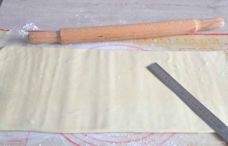 Второй этап прослаивания. Расположите тесто узкой стороной прямоугольника к себе, длинный шов ("ключ" — сбоку), раскатывайте тесто от центра к краям в длину, добиваясь, чтобы толщина пласта была 4-5 мм.
