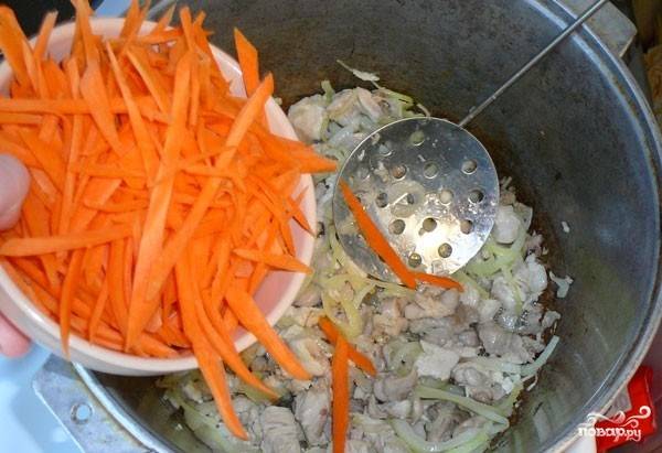 Морковь очистите и хорошенько вымойте. Нарежьте ее ножом или при помощи специальной терки на длинную соломку. Подготовленную морковку добавьте к луку с мясом и обжаривайте на протяжении пяти минут. 