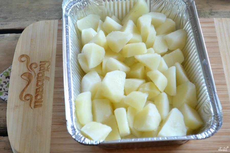 Форму для запекания застелите фольгой. Выложите в неё отваренный картофель.