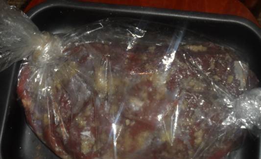 3. Такой пакет помещаем на противень и запекаем мясо час в предварительно разогретой до 200 градусов духовке.